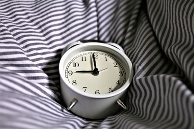 High angle view of clock on bed at home