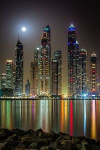 Illuminated buildings against sky at night