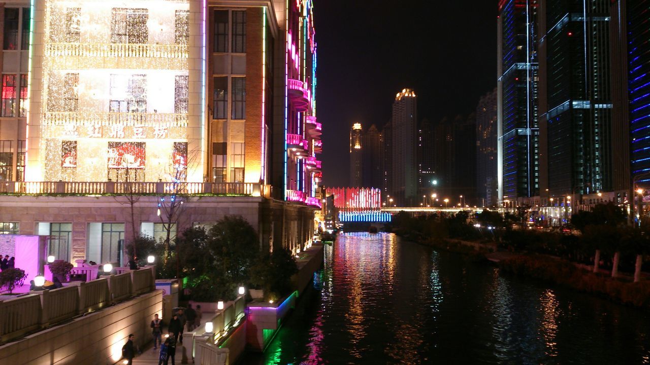 building exterior, architecture, built structure, illuminated, city, night, transportation, street, city life, reflection, building, street light, water, car, city street, incidental people, road, mode of transport, the way forward, lighting equipment