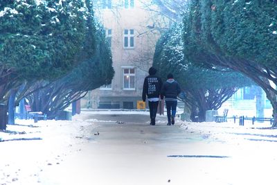 People walking on snow covered city in winter