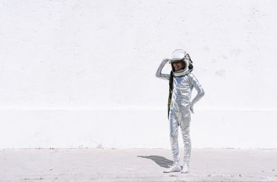 Man standing against white wall