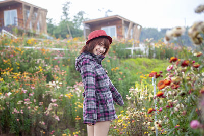 Portrait of smiling woman standing against plants