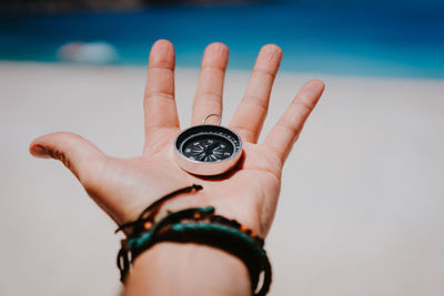 Close-up of hand holding compass on palm of hand