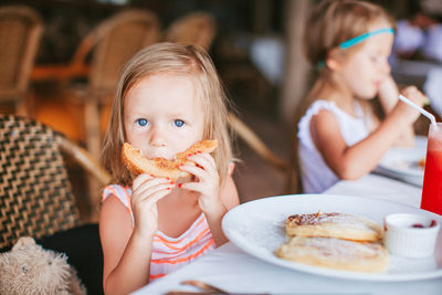 Close-up portrait of girl eating food at cafe