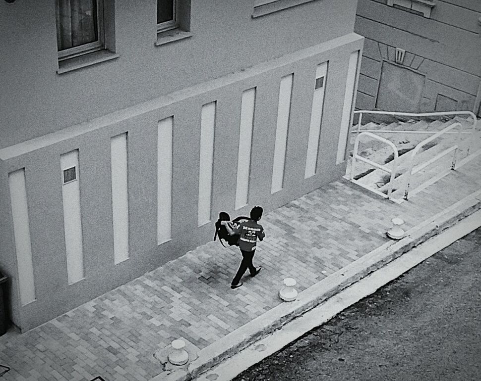 BOY PLAYING WITH UMBRELLA ON BUILDING