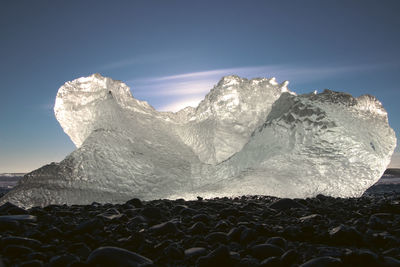 Beautiful chunks of ice with the sun reflecting, washed up on jokulsarlon beach, iceland at sunrise.