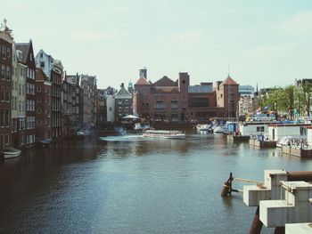 Canal in city against sky