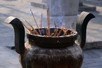 Close-up of incense sticks in container at temple