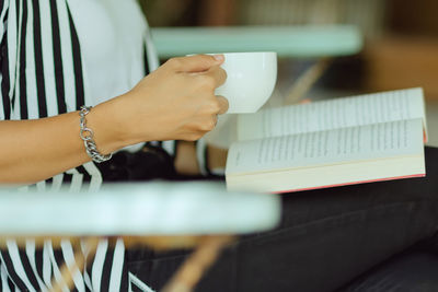 Midsection of woman holding coffee cup