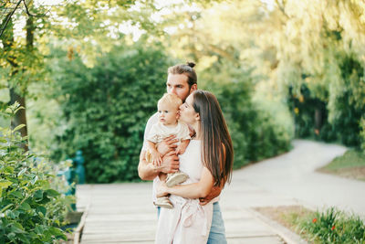 Parents with cute son standing in park