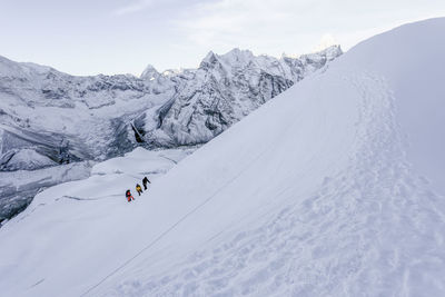 People skiing on snow covered landscape