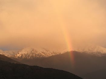 Scenic view of rainbow over mountains against sky