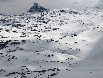 Aerial view of snow covered landscape against sky