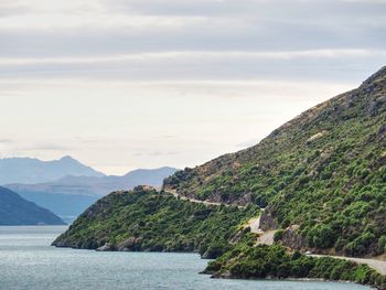 Scenic view of sea and mountains against sky