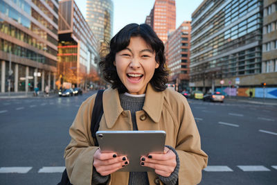 Young woman using mobile phone in city