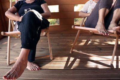 Low section of people sitting on wood