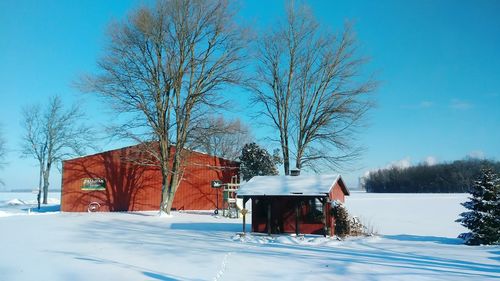 Built structure on snow field against clear blue sky