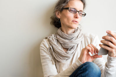 Young woman looking away while sitting outdoors