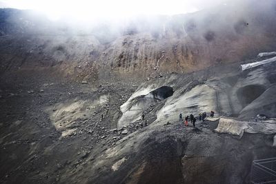 People on snowcapped mountain against sky