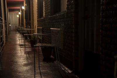 Empty alley amidst buildings in city at night