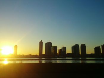 Skyscrapers in city at sunset