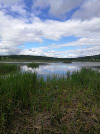 Scenic view of lake against cloudy sky