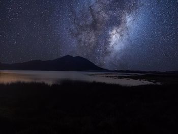 Scenic view of lake against sky at night