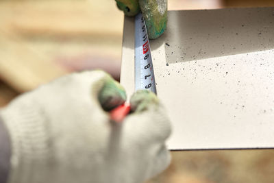 Cropped hand of carpenter using tape measure