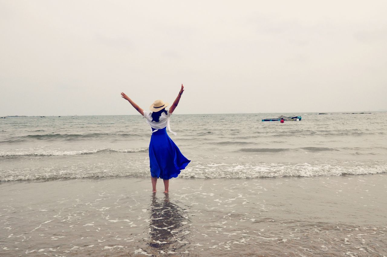 sea, beach, horizon over water, water, full length, leisure activity, shore, lifestyles, sand, vacations, clear sky, rear view, standing, wave, copy space, casual clothing, scenics, sky