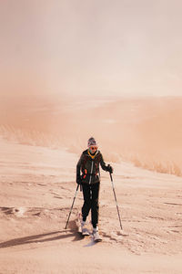 Rear view of man standing on snow covered landscape