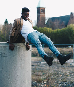 Young man jumping from retaining wall