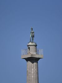 Low angle view of statue against blue sky