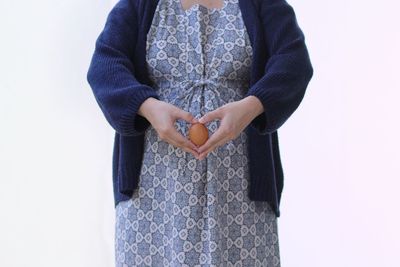 Midsection of woman standing against white background