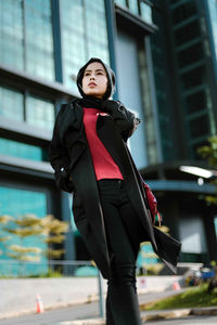 Young woman standing outside building 