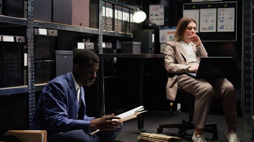 Young woman using mobile phone while sitting in office