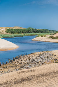 Scenic view of beach against clear blue sky