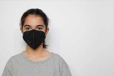 Portrait of beautiful woman covering face against white background