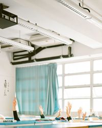 Cropped image of hands raised in classroom