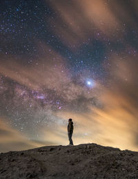 Full length of woman standing on land against sky at night