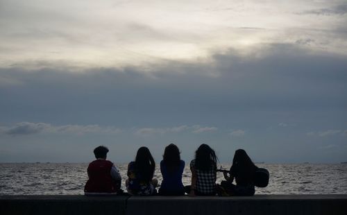 Rear view of man overlooking calm sea
