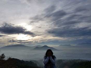 Woman photographing against sky