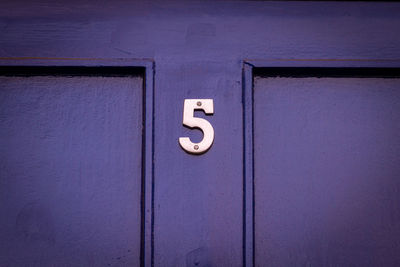House number 5 on a blue wooden front door
