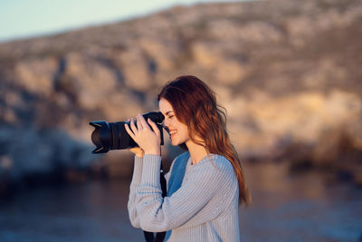 Woman photographing with umbrella