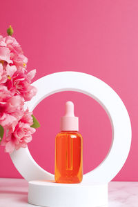 Glass dropper bottle on pink background. skin care concept. cosmetic container mock-up