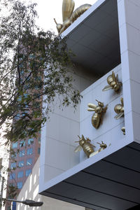 Low angle view of tree against building