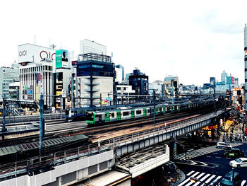 Train at railroad station in city against sky