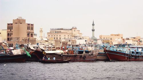 Boats in harbor with buildings in background