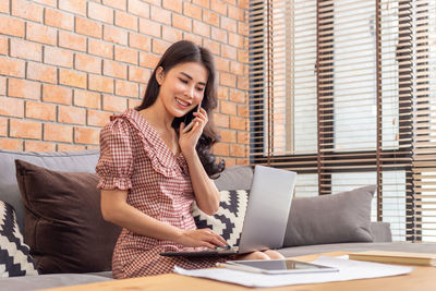 Smiling young woman using mobile phone