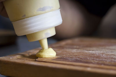 Putting mustard in a wooden board