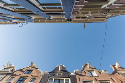 Low angle view of buildings against clear blue sky